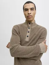 Sweater de punto color tostado con cuello alto y medio cierre frontal con botones. Presenta mangas largas con puños acanalados y diseño de tejido texturizado.