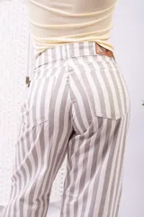 Pantalón de tiro alto y pierna ancha con estampado de rayas verticales en tonos blanco y beige, corte holgado y relajado.