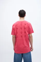 Remera color coral con estampa en la espalda que dice 'Sunset'.