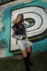 Campera negra de cuero sintético con mangas largas con lentejuelas plateadas.