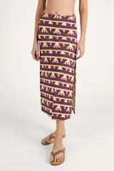 Falda larga de corte recto con diseño envolvente, drapeado asimétrico y detalle de argolla lateral. Presenta un estampado geométrico en tonos naranja, fucsia, azul y crema.