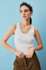Musculosa blanca de punto acanalado, con escote redondo y diseño ajustado al cuerpo.