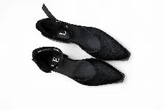 Sandalias bajas de cuero con estampado animal print de vaca en blanco y negro, con pulsera al tobillo y taco cuadrado.