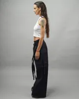 Pantalón cargo negro de gabardina, corte amplio, con múltiples bolsillos y tiras ajustables.