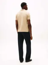 Chomba color arena de Tommy Hilfiger Sport, confeccionada en piqué de mezcla de algodón elástico con tecnología Flex, que absorbe la humedad y es antiolor. Tiene corte regular, cuello de chomba, cartera de dos botones y logo de la marca bordado en el pecho.