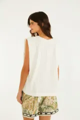 Musculosa blanca de algodón, con hombreras estructuradas y cuello redondo. Estampado frontal en negro estilo ilustración de Río de Janeiro con loros, flores y paisaje tropical.
