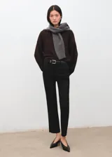 Pantalón de vestir negro de corte recto y tiro medio, con trabillas para cinturón y bolsillos sutiles.
