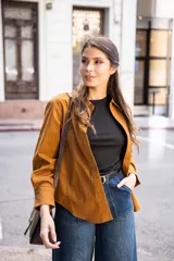 Camisa marrón de corte clásico, con tejido suave y textura cálida. Tiene un bolsillo decorativo discreto y botones al tono.