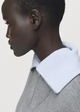 Chaleco de punto de corte recto y diseño minimalista, con cuello alto y cierre frontal de cremallera.
