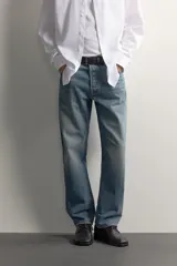 Jeans regular fit confeccionados en denim de algodón celeste con efecto lavado, de cinco bolsillos y cierre frontal con cremallera y botón.