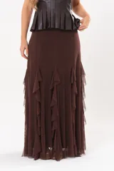 Pollera larga color chocolate confeccionada en microtul, totalmente forrada, con diseño fluido y volados en cascada que aportan movimiento.