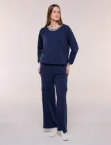 Pantalón jogger azul marino de corte recto y ancho, confeccionado en modal. Presenta pretina elastizada, bolsillos tipo cargo en los laterales y costuras verticales decorativas.