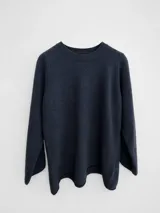 Sweater de punto de corte holgado y diseño minimalista, con cuello redondo y mangas largas. Presenta una textura suave y un largo que llega por debajo de la cadera.