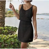Vestido corto de playa tejido con diseño calado, sin mangas y cuello redondo. Presenta un calce adaptable al cuerpo.