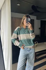 Sweater de punto con cuello polo y botones, a rayas horizontales color marrón y beige.