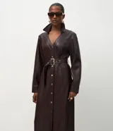 Vestido midi tipo chemise confeccionado en poliuretano color marrón oscuro. Presenta cuello estructurado, cierre frontal con botones metálicos, mangas largas y cinturón ajustable con hebilla metálica a tono.