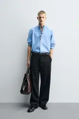 Pantalón de corte wide fit confeccionado en pana de algodón color marrón oscuro. Presenta bolsillos frontales, bolsillos traseros de vivo con botón y cierre frontal con cremallera y botón.