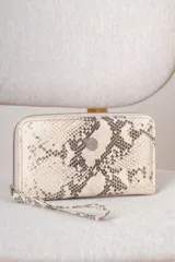 Billetera tipo sobre con cierre perimetral y correa de muñeca extraíble. Presenta un diseño estampado con textura de piel de serpiente en tonos beige y gris, con un aplique metálico circular en el frente.