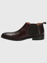 Bota tipo Chelsea de cuero en color bordó, con paneles laterales elásticos y suela de goma negra.