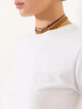 Remera blanca de algodón con cuello redondo y manga corta, de calce clásico y largo a la primera cadera. Presenta aplique hotfix en el delantero y logo bordado en la espalda.