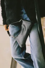 Bolso de hombro de diseño alargado y estructura rígida, confeccionado en material con acabado efecto cuero envejecido. Cuenta con asa corta ajustable mediante herrajes metálicos dorados, cierre principal de cremallera y compartimentos internos.