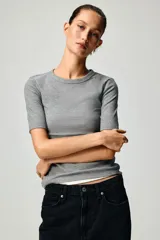 Remera de manga corta en punto acanalado, de modelo entallado con cuello redondo ribeteado.