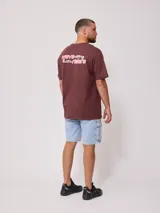 Remera de corte oversize color bordó, con cuello redondo y estampado gráfico en el pecho con la leyenda 'wave riders'.