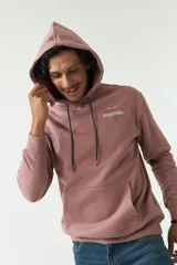 Canguro con capucha de algodón y poliéster en color rosado. Presenta una estampa gráfica en la espalda con diseño de estatua clásica y tipografía, además de un logo en grifa de goma en la manga.