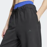 Pantalón deportivo Adidas negro, de corte holgado, confeccionado en felpa con tecnología AEROREADY. Presenta cintura elástica con cordón ajustable y puños elásticos en los tobillos.