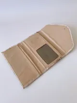 Billetera de cuero color crudo con textura, cierre con broche y monedero externo.