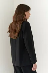 Blazer negro de poliéster, viscosa y spandex, con forro animal print, hombreras, botones frontales y en mangas.