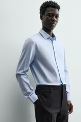 Camisa de hombre color beige claro, de corte slim fit, con cuello italiano, manga larga y cierre frontal de botonadura.