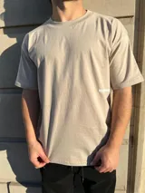 Remera de corte semi oversize en color beige, con estampado gráfico en la espalda que incluye la frase 'BUENA VIBRA' en letras grandes y 'feel the vibes' en tipografía cursiva, además de un pequeño logo bordado en la nuca.
