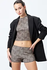 Short tiro alto con estampado animal print, confeccionado en tejido de punto con textura acanalada y ribete negro.