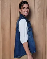 Chaleco de gabardina color tostado, con cuello camisero, cierre frontal con botones metálicos y dos bolsillos frontales con solapa.