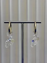 Aros tipo argolla de acero quirúrgico con dije colgante de cristal de Murano transparente con detalles en azul y una pequeña perla incrustada.