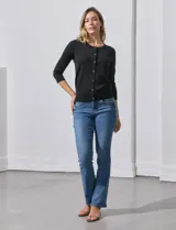 Cardigan blanco de tejido fino con abertura central y botones.