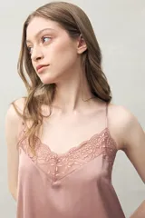 Top de pijama color rosado, confeccionado en tejido satinado con leve elasticidad. Presenta un escote en V con encaje floral y tiras finas regulables.