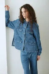 Campera de denim azul con múltiples bolsillos frontales con solapa, cierre frontal de botones metálicos y cuello camisero.