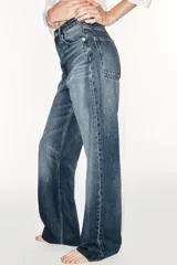 Jeans de tiro alto y estilo wide leg, con diseño de cinco bolsillos, lavado oscuro con efecto desgastado, pierna ancha larga y bajo sin costuras.