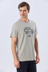 Remera Legacy de manga corta y cuello redondo, color azul melange, con estampa frontal y detalles bordados de un vehículo todoterreno acompañados por el texto "The Adventure Club".