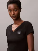 Remera de Calvin Klein confeccionada en punto de algodón elástico con textura de canalé fino. Presenta un diseño de corte slim, cuello en V, manga corta y una insignia con el logo de la marca en el pecho.