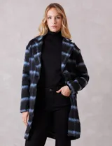 Tapado símil mohair, marca Dictionary, con estampado a cuadros en negro y azul. Tiene cuello con solapa, cierre frontal con botones y bolsillos delanteros. Incluye forro interno a tono.