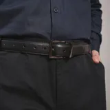 Cinturón de cuero negro liso con hebilla metálica cuadrada de color plateado oscuro.