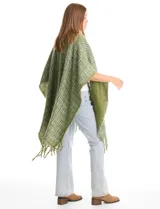 Ruana de tejido tweed con hilos de lurex, diseño abierto con terminación de flecos en los bordes.