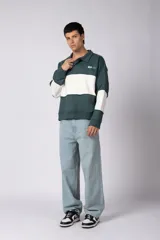 Buzo tipo polo de calce relajado con diseño de bloques de color en tonos marrón y blanco. Presenta cuello polo, cierre frontal parcial y logo estampado en el pecho. Confeccionado en tejido pesado con estructura.