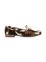 Mocasín Galeano confeccionado en cuero con pelo vacuno, con diseño de estampado animal print estilo vaca en tonos marrón y blanco, con suela plana y taco bajo de goma.