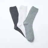 Pack de tres pares de medias de caña alta con diseño de canalé, en tonos gris oscuro, blanco y gris claro.
