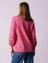 Blusa blanca con bordado calado tipo broderie, de mangas largas abullonadas.