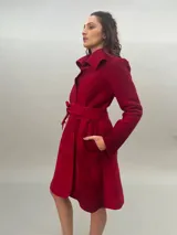 Tapado rojo de lana merino afieltrada, corte recto con lazos para ajustar en la cintura y cuello alto con posibilidad de cruzar los lazos alrededor. Tiene bolsillos laterales.